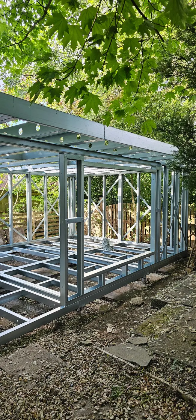 Light gauge steel garden room frame with floor structure, braced wall panels and flat roof members assembled on site