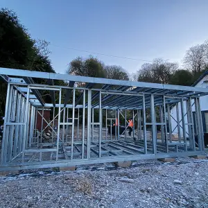 Compact light gauge steel garden room frame assembled on a residential site